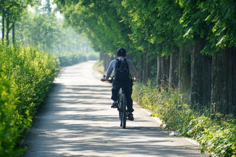Versicherungsvermittler fährt mit einem Fahrrad zur Arbeit durch die Natur..