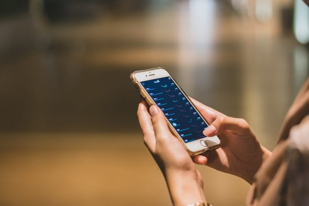 Eine Frau nutzt einen Online-Broker auf ihrem Smartphone.