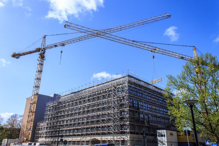 Eine Baustelle mit Gerüst und Krähnen symbolisiert den Impact nachhaltiger Entscheidungen.